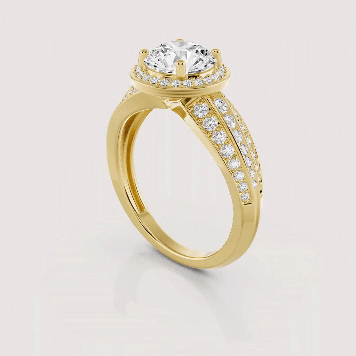 A yellow gold ring with a round-cut diamond center stone, a halo of small diamonds, and a split shank paved with diamonds, shown on a light gray background.