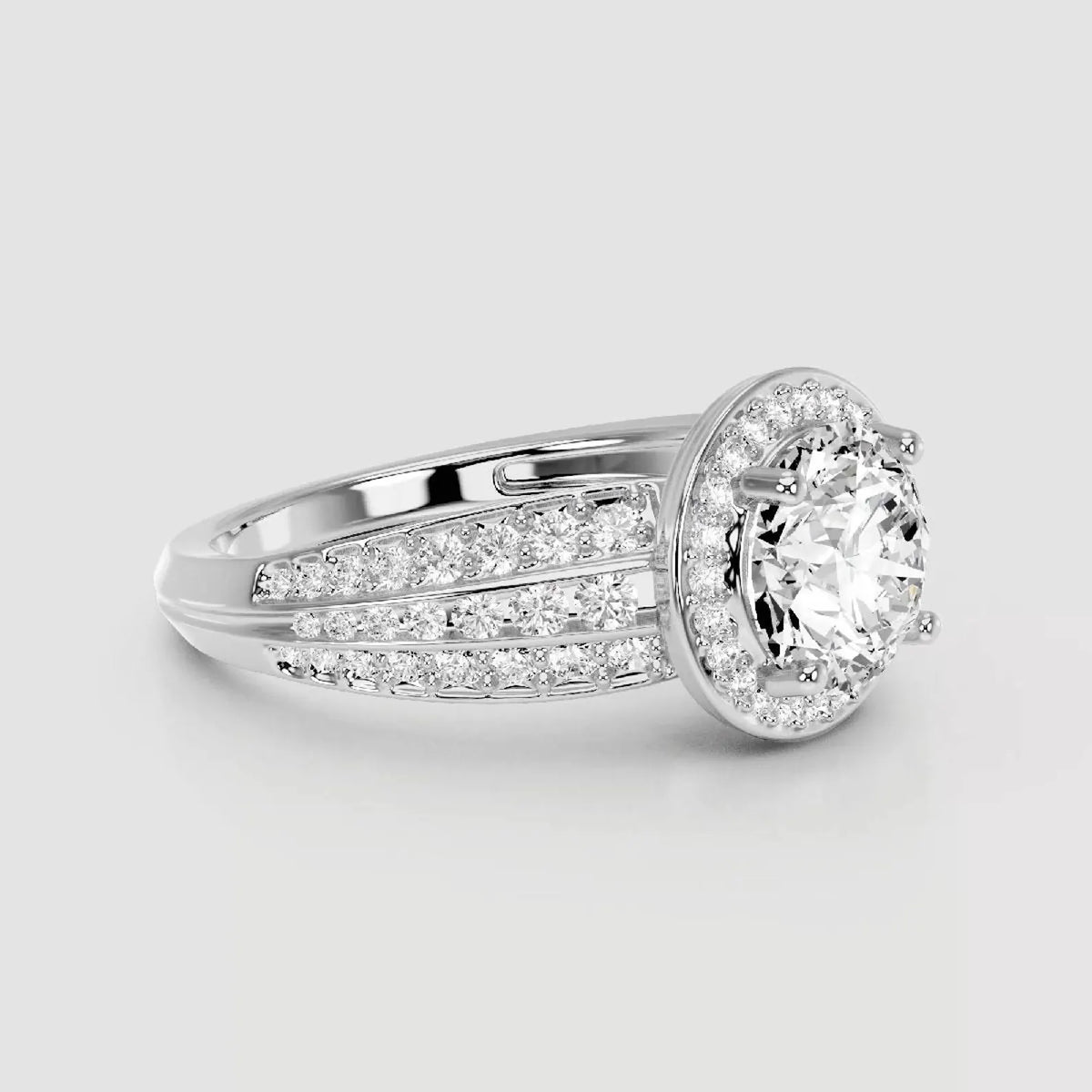 A silver-toned diamond ring with a round-cut center stone surrounded by a halo and pavé-set side stones on a light gray background.