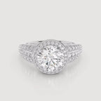 A silver-toned diamond ring with a large round center stone surrounded by a halo, and smaller diamonds set along the split shank, shown on a light gray background.