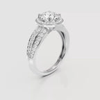 A silver-tone diamond engagement ring with a round-cut center stone and pavé-set side stones, shown on a light gray background.