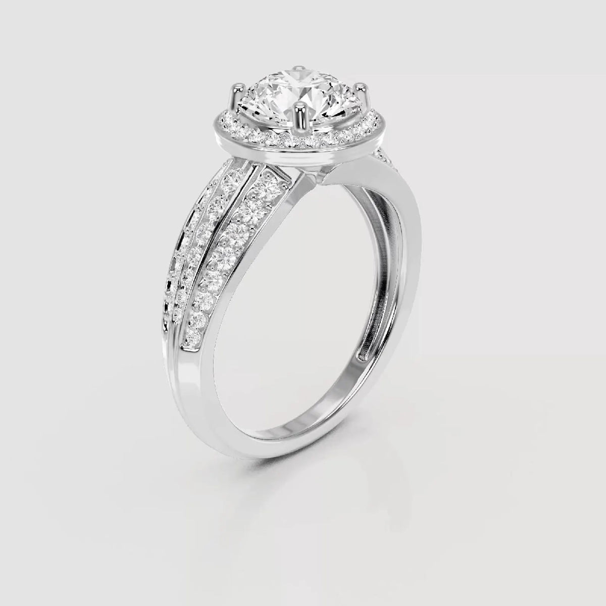 A silver-tone diamond engagement ring with a round-cut center stone and pavé-set side stones, shown on a light gray background.