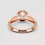 A rose gold ring with a unique bow-like split band design and a single clear round-cut gemstone in the center, shown on a light gray background.