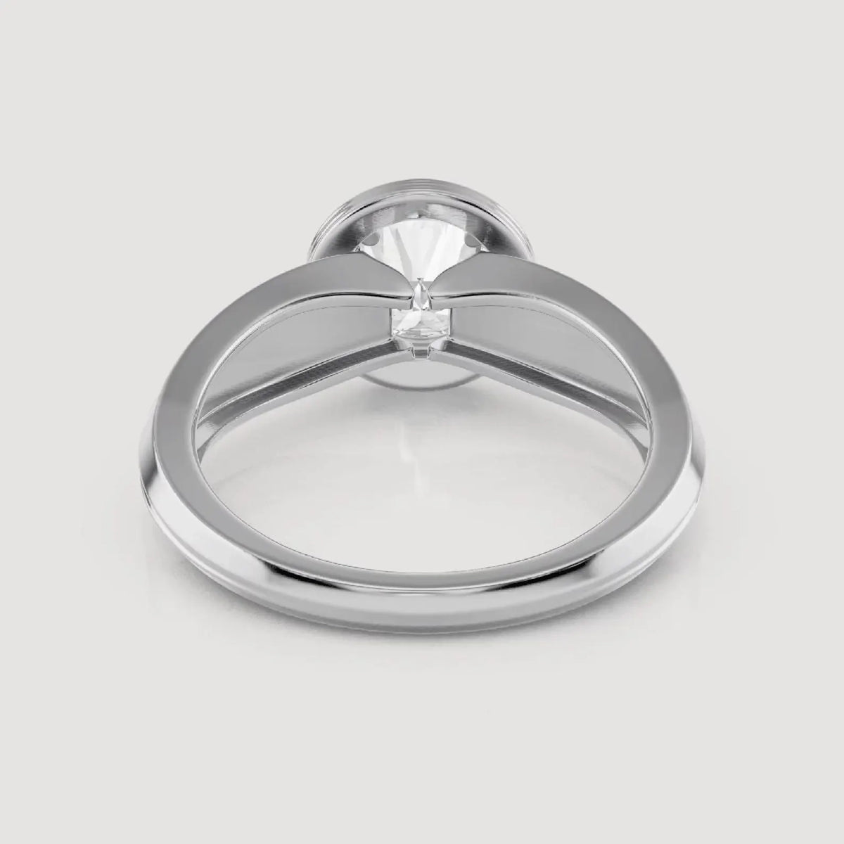 A polished silver-toned ring with a large clear gemstone in a prong setting, shown from a top-down view on a light gray background.