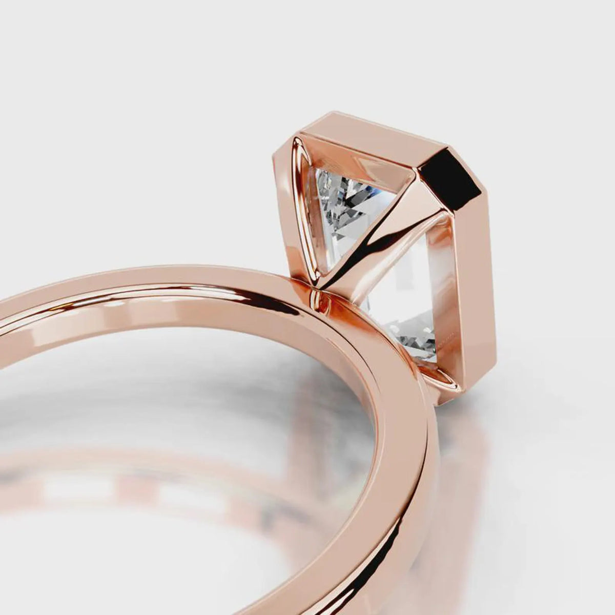 Close-up view of the open gallery basket under a 4 CT emerald lab diamond in rose gold bezel setting.