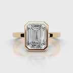 Direct top-down view of a 4 CT emerald cut lab diamond in a full yellow gold bezel setting.