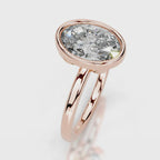 Angled front view of a 4 CT oval cut lab grown diamond ring with smooth rose gold bezel setting.