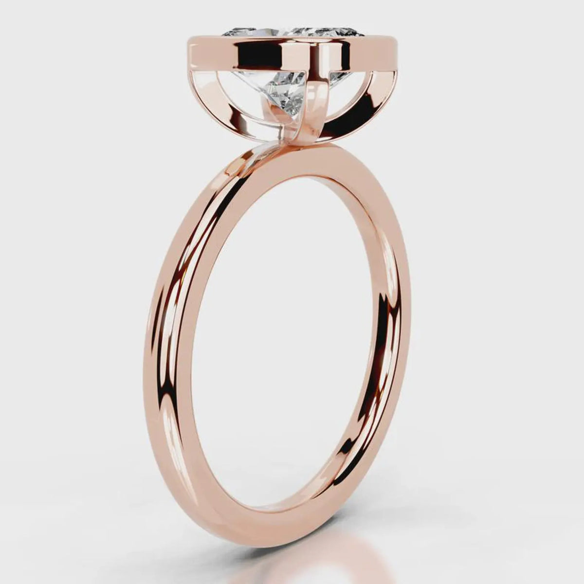 Side profile view of a 4 CT cushion cut lab grown diamond bezel ring in rose gold.