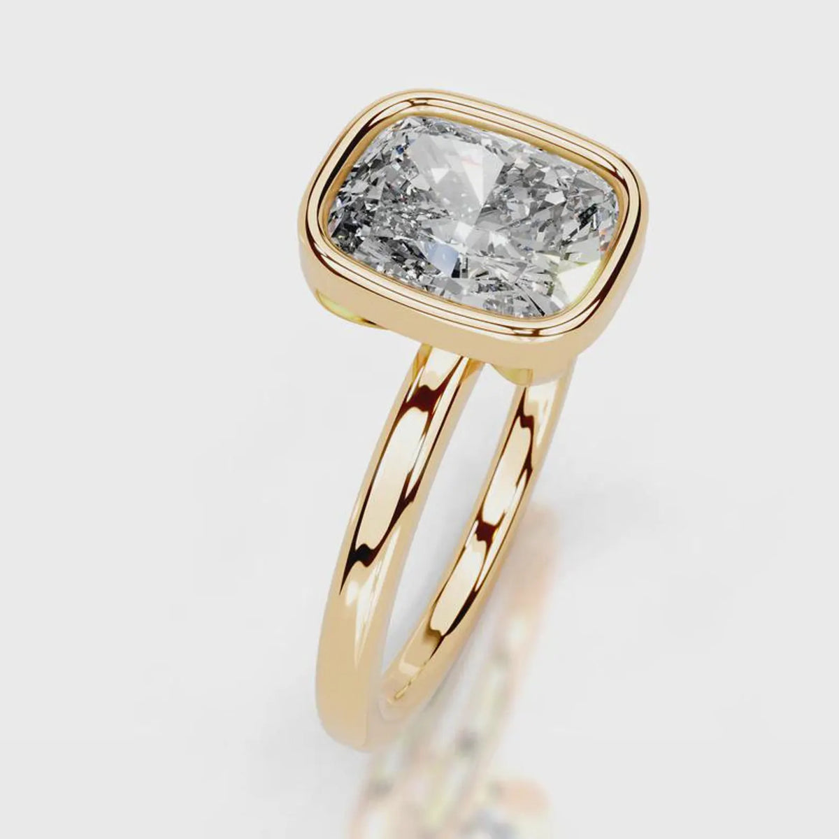 Three-quarter perspective of a 4 CT cushion lab grown diamond bezel ring in yellow gold.