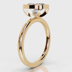 Side profile view of a 4 CT cushion cut lab grown diamond bezel ring in yellow gold.