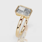 A gold ring featuring a large, bezel-set rectangular emerald-cut diamond. The diamond is clear and does not contribute to the color mapping according to the schema rules, so the product color is determined solely by the gold metal setting and band.