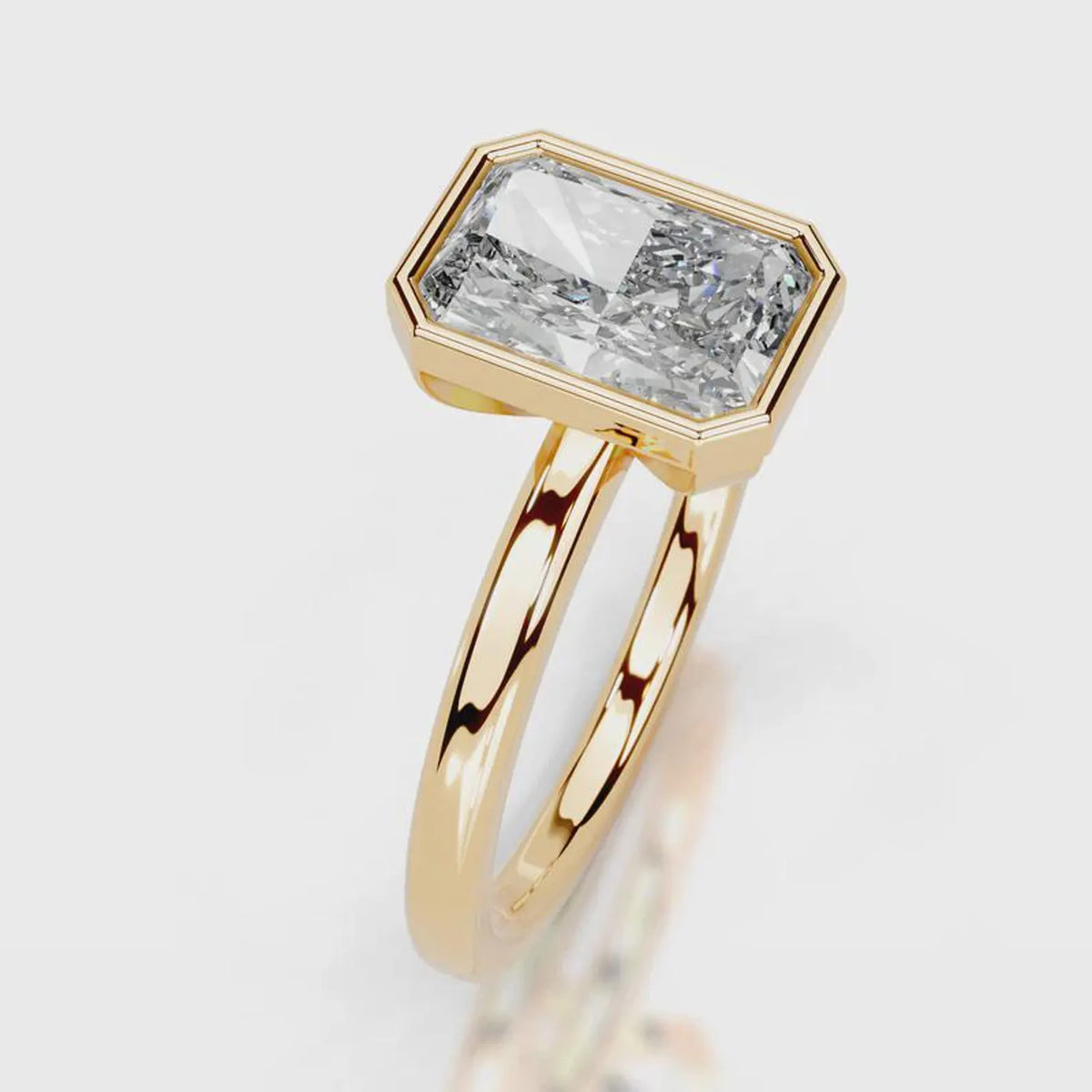A gold ring featuring a large, bezel-set rectangular emerald-cut diamond. The diamond is clear and does not contribute to the color mapping according to the schema rules, so the product color is determined solely by the gold metal setting and band.