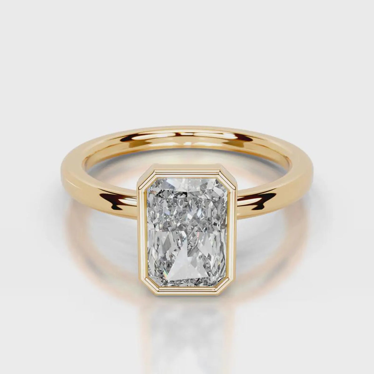 A yellow gold ring featuring a large, bezel-set rectangular emerald-cut diamond. The diamond is clear and does not contribute to the color mapping according to the schema rules, so the product color is determined solely by the gold metal band.