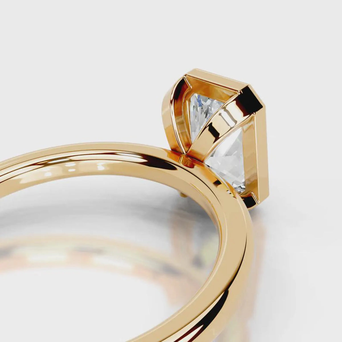 Close-up of open under-gallery on 4 CT radiant lab grown diamond bezel ring in yellow gold.