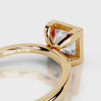 Close-up of open under-gallery on 4 CT princess cut lab grown diamond bezel ring in yellow gold.