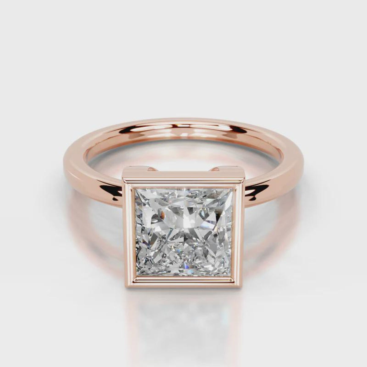 Direct front view of 4 CT princess cut lab grown diamond bezel solitaire ring in rose gold.