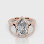 Direct front face-up view of 4 CT pear cut lab grown diamond bezel solitaire ring in rose gold.