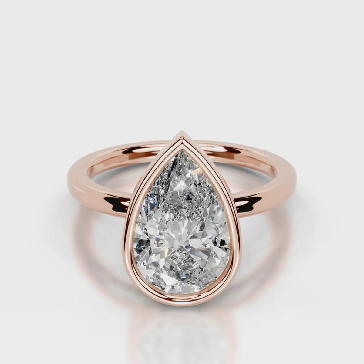 Direct front face-up view of 4 CT pear cut lab grown diamond bezel solitaire ring in rose gold.