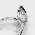 Close-up under-bezel view of 4 CT pear cut lab grown diamond ring in white gold.