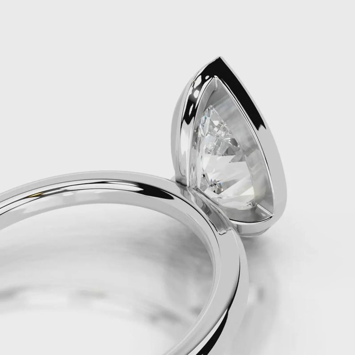 Close-up under-bezel view of 4 CT pear cut lab grown diamond ring in white gold.
