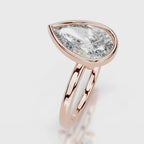 Angled perspective view of 4 CT pear cut lab grown diamond bezel ring in rose gold.