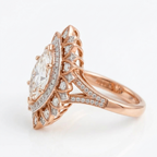 Side profile view of a rose gold marquise diamond engagement ring displaying the cathedral setting and pave split band.
