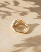 Underside view of a solid yellow gold chunky bezel ring showing the teardrop cutout for a 2 carat pear lab diamond.