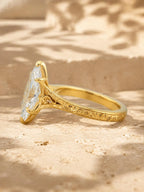 Side profile view of a 4 carat marquise lab grown diamond engagement ring with hand-engraved scrollwork in yellow gold.