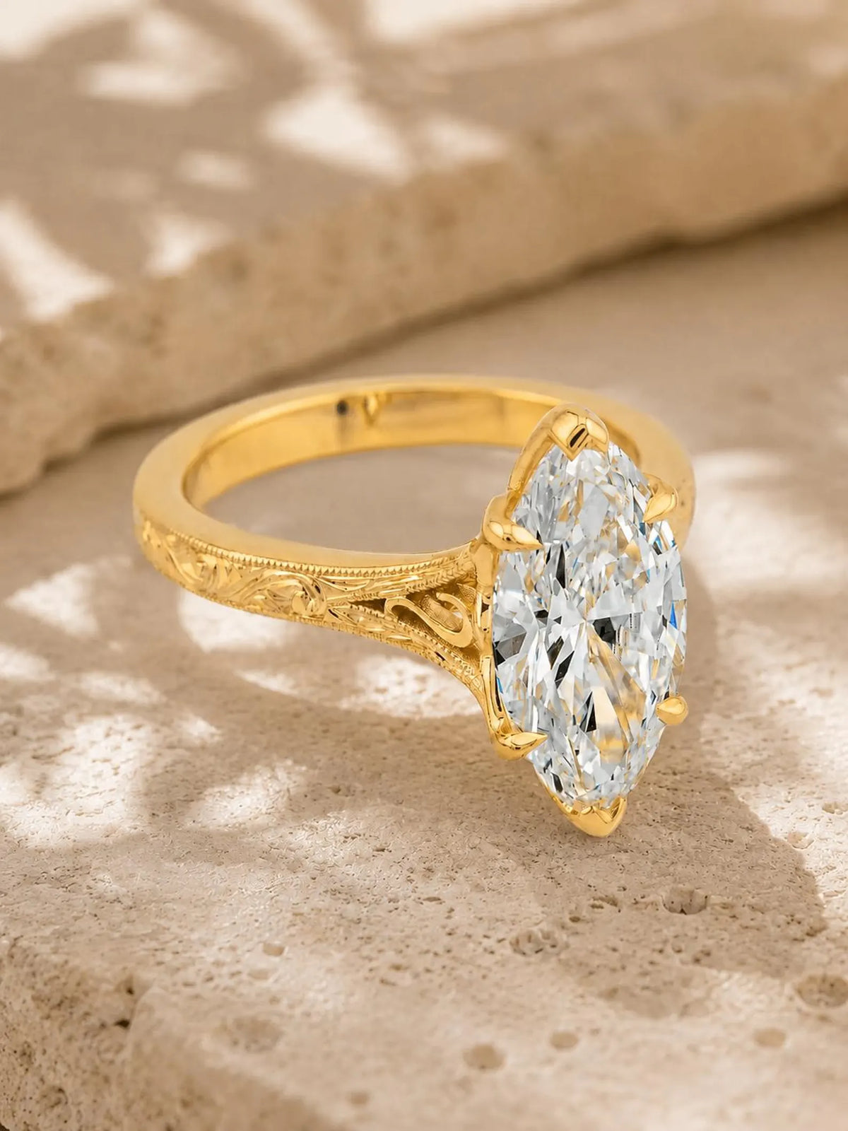 Top-angled view highlighting the brilliance of a 4 carat marquise lab grown diamond on an engraved yellow gold band.