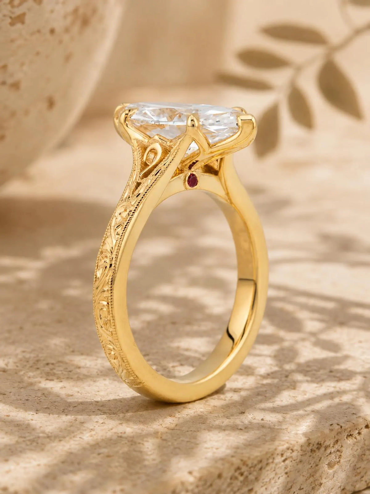 High-angle side view of a cathedral marquise lab diamond engagement ring with engraved band and surprise hidden gemstone.