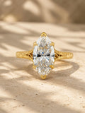 Top-down front view of a 4 carat marquise cut lab grown diamond in a 6-prong yellow gold setting with hand-carved shoulders.