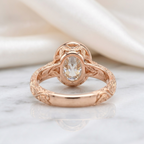 Underside back view of a rose gold 3 carat oval lab grown diamond ring showing leaf-engraved bezel gallery and stamp.