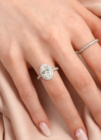 Full hand modeling shot of a 3 CT oval lab diamond halo engagement ring paired with a pavé stackable band.