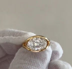 Top-down view of a 4 carat oval cut lab grown diamond set horizontally in a yellow gold bezel frame.