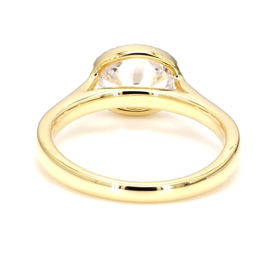 Side view under the setting showing the open gallery structure of an East-West oval lab diamond bezel ring.