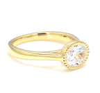 Front three-quarter angle view of a 2 carat oval lab grown diamond engagement ring with milgrain edge bezel.