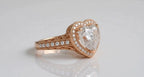 Angled shot highlighting 4 CT heart cut diamond, milgrain halo, and side pearl scrollwork.