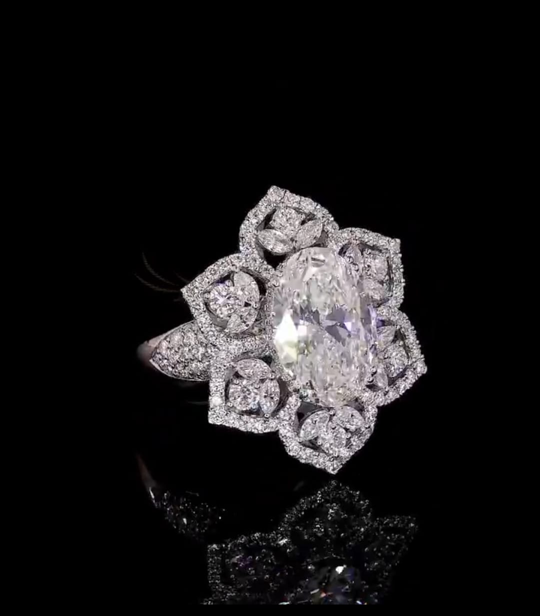 Angled top view showing geometric symmetry of starburst floral halo and oval stone.