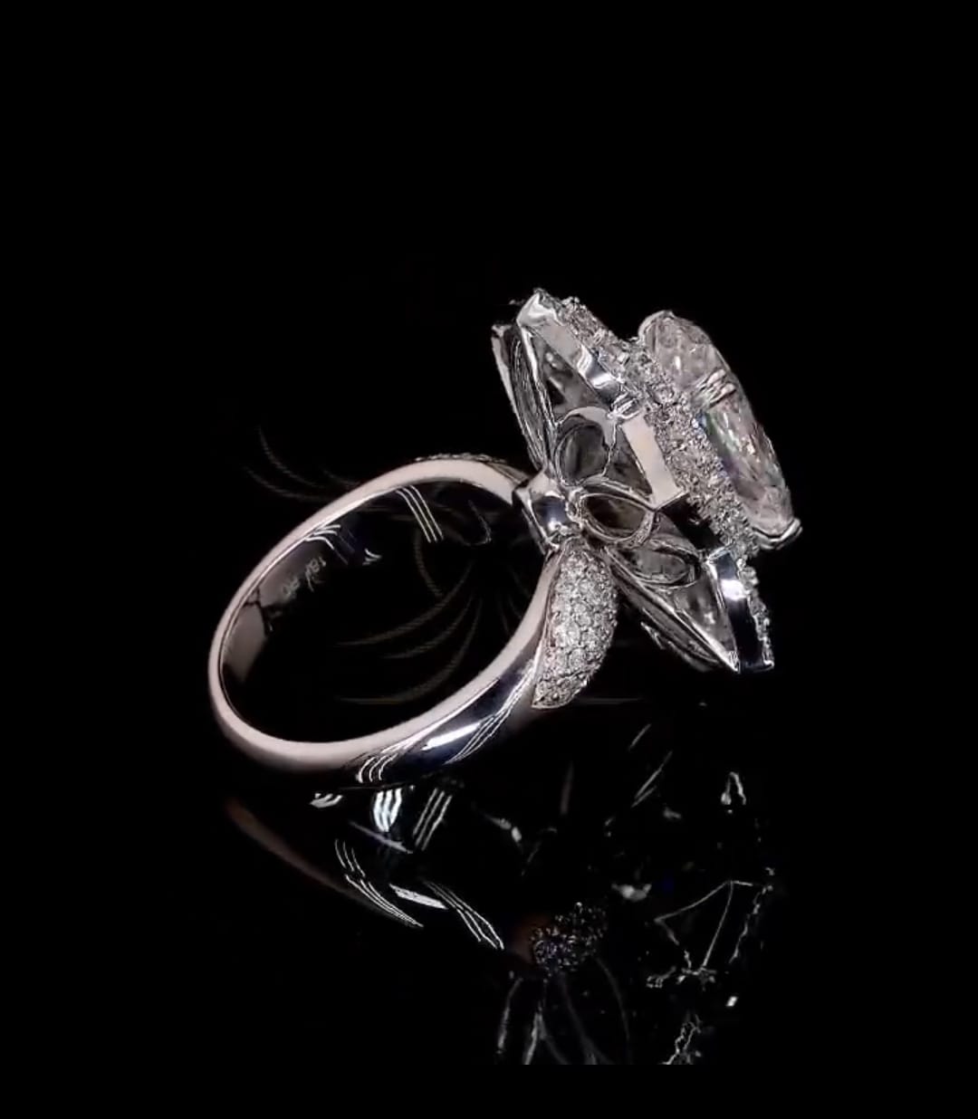 Side view highlighting high-set floral setting support and polished white gold shank.