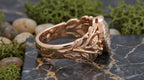 Side profile of 3 CT oval lab diamond ring with rose gold leaf and branch band details.