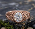 Overhead view of 3 CT oval cut lab grown diamond in a textured rose gold bezel setting.