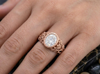 Close-up on-hand shot of 3 CT oval lab diamond engagement ring with leaf branch motif.
