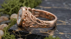 Angled side view showing hand-carved rose gold leaves and berry accents on diamond ring band.