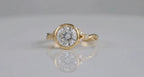 Front reflection view of 3 CT round lab grown diamond bezel ring in yellow gold.