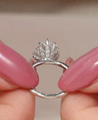 Close-up side view showing the pavé-accented lotus petal basket setting cradling a heart-cut lab diamond.