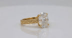 Side angled shot of 4 CT oval lab diamond featuring claw prongs and engraved pattern band.