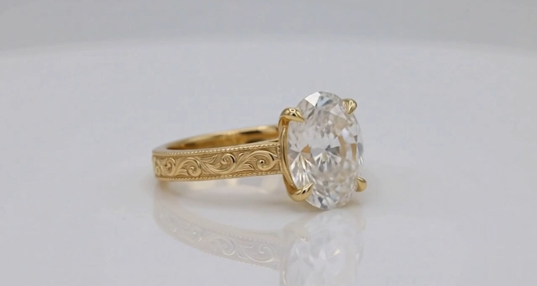 Side angled shot of 4 CT oval lab diamond featuring claw prongs and engraved pattern band.