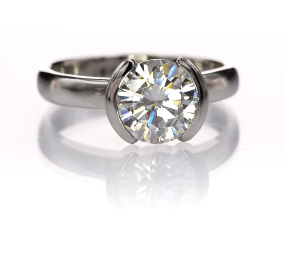 Front view of a 2 CT round lab grown diamond ring in a half-bezel white gold solitaire setting.
