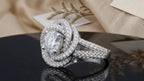 Angled view displaying the floral swirl pave halo and split shank of a 2 CT round lab diamond ring.