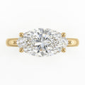 Top-down view of a 3 CT marquise cut lab diamond set horizontally in an East-West yellow gold ring.