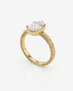 Angled view showcasing the 4 CT oval lab grown diamond, scalloped basket setting, and scrollwork filigree band in yellow gold.